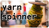 A bobbin of handspun yarn with the text 'yarn spinner' next to it.